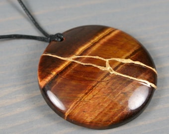 Kintsugi repaired red tiger eye pendant on and adjustable length black cotton cord necklace