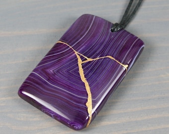 Kintsugi repaired purple banded agate pendant on an adjustable black cotton cord necklace
