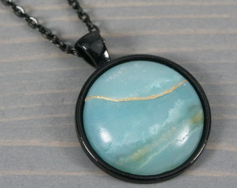 Kintsugi repaired amazonite pendant in a black bezel setting on cable chain