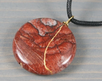 Kintsugi repaired red picture jasper pendant on an adjustable black cotton cord necklace