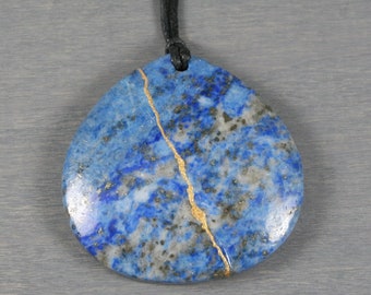 Kintsugi repaired lapis lazuli pendant on an adjustable black cotton cord necklace