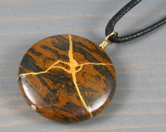 Kintsugi repaired tiger iron pendant on an adjustable length black cotton cord necklace
