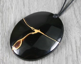 Kintsugi repaired black onyx pendant on an adjustable length black cotton cord necklace