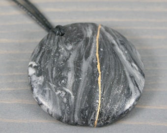 Kintsugi repaired black and grey marble pendant on black cotton cord