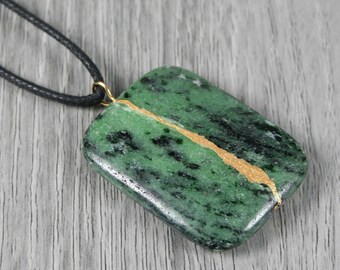 Kintsugi repaired ruby in zoisite pendant on a thick, adjustable length black cotton cord necklace