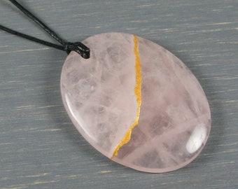 Kintsugi repaired rose quartz pendant on an adjustable length black cotton cord necklace