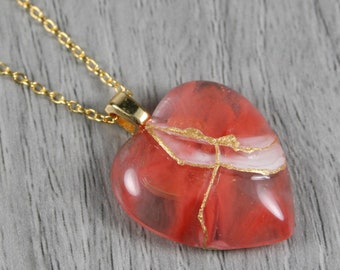 Broken heart pendant in cherry quartz with kintsugi repair on a cable chain necklace