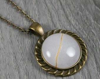 Kintsugi repaired white agate pendant in an antiqued brass setting on chain