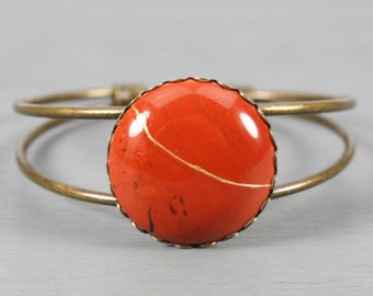 Kintsugi repaired red jasper bracelet in an antiqued brass cuff bangle bracelet setting