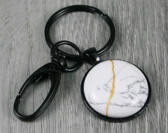 Kintsugi repaired white howlite stone key chain in a black bezel setting with swivel lobster claw