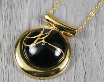 Kintsugi repaired black agate pendant in a gold plated setting on a chain necklace