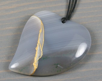 Kintsugi repaired gray banded agate broken heart pendant on an adjustable black cotton cord necklace