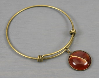 Carnelian kintsugi charm on an antiqued brass bangle bracelet