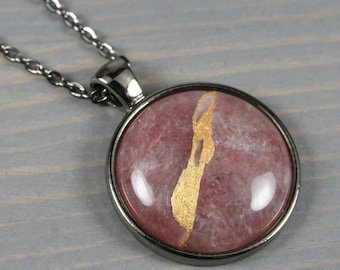 Kintsugi repaired strawberry quartz pendant in a gunmetal plated bezel setting on a chain necklace