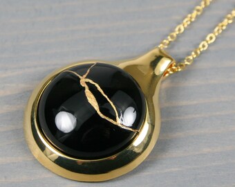 Kintsugi repaired black agate pendant in a gold plated setting on a cable chain necklace