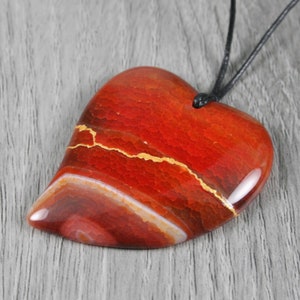 Kintsugi repaired red-orange dragon veins agate broken heart pendant on an adjustable length black cotton cord necklace