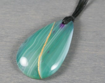 Kintsugi repaired green and purple agate teardrop pendant on an adjustable length black cotton cord necklace