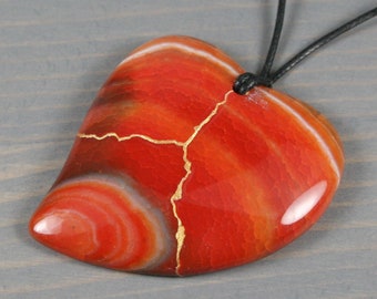Kintsugi repaired red-orange dragon veins agate broken heart pendant on black cotton cord