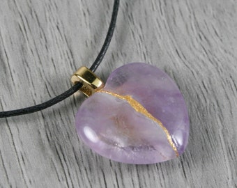 Broken heart pendant in amethyst with kintsugi repair on a black cotton cord necklace