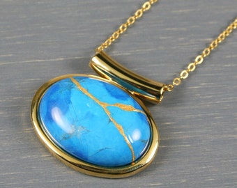 Kintsugi repaired turquoise howlite pendant in a gold plated setting on a cable chain necklace