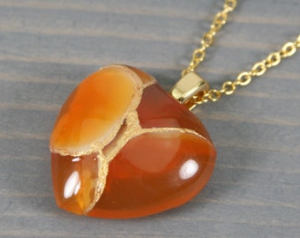 Broken heart pendant in carnelian with kintsugi repair on a cable chain necklace