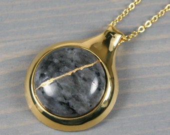 Kintsugi repaired larvikite pendant in a gold plated setting on a cable chain necklace