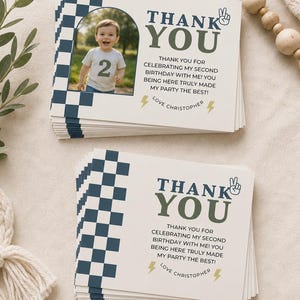 May include: A stack of rectangular thank you cards featuring a navy blue and white checkered pattern on the left side. The cards include a photo of a child wearing a shirt with the number 2, the text THANK YOU, and the message LOVE CHRISTOPHER.