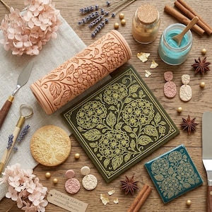 May include: A collection of craft supplies and finished products, including a floral-patterned rolling pin, square tiles, earrings, and a round coaster. The color palette includes shades of pink, green, and gold, with cinnamon sticks and star anise adding warmth.