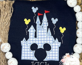 May include: A navy blue sweatshirt with an embroidered design of a blue and white checked castle with Mickey Mouse ears in the front. The castle has yellow and blue balloons with red flags. The name "JACK" is embroidered below the castle.
