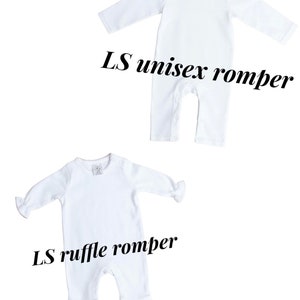 May include: Two white baby rompers. The top romper is a long-sleeve unisex romper. The bottom romper is a long-sleeve ruffle romper.