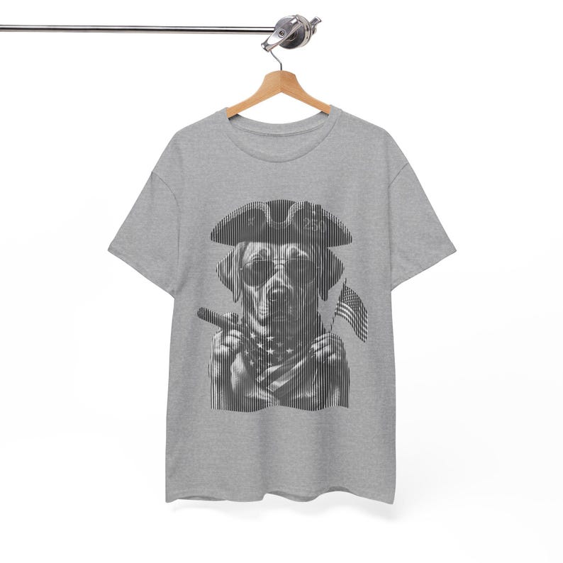 May include: A heather gray short-sleeve t-shirt featuring a black and white graphic of a dog wearing a tricorn hat and sunglasses, holding a cigar, and wearing a star-patterned bandana, with a small American flag visible in the background.