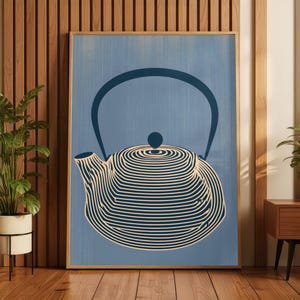 May include: A framed wall art print featuring a stylised dark blue teapot illustration against a light blue background. The teapot design is composed of concentric horizontal lines that create a circular shape with a curved handle and spout.