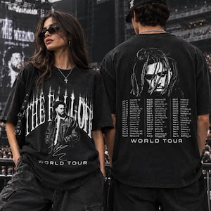 May include: A black short-sleeve t-shirt featuring a graphic of J. Cole with the text The Fall Off World Tour on the front and a portrait of the artist with a list of tour dates and the text World Tour printed on the back of the garment.