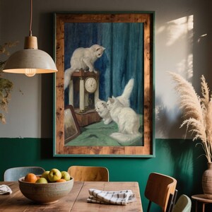 Op de afbeelding: Een ingelijste kunstdruk met drie witte katten verzameld rond een vintage houten klok tegen een achtergrond van donkerblauwe gordijnen. Het kunstwerk zit in een rustieke houten lijst en hangt aan een muur met een groen onderste gedeelte.