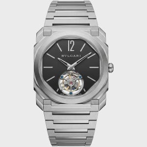 Op de afbeelding: Een zilverkleurig roestvrijstalen polshorloge met een achthoekige kast en een bijpassende geïntegreerde schakelarmband. De zwarte wijzerplaat toont de tekst BVLGARI, een groot cijfer 12, zilveren wijzers en een zichtbaar tourbillon op zes uur.