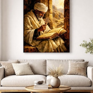 Puede incluir: Una impresi&oacute;n en lienzo enmarcada representa a una persona mayor con turbante y t&uacute;nica blancos, leyendo un libro y sosteniendo una cruz. La obra de arte est&aacute; ambientada en una puerta de piedra con un paisaje visible al fondo. La paleta de colores es c&aacute;lida, con tonos terrosos.