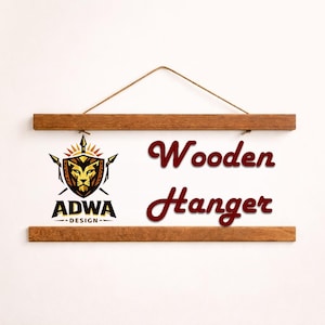 Puede incluir: Una percha de madera con acabado natural, suspendida por un cord&oacute;n marr&oacute;n. Las palabras "Wooden Hanger" est&aacute;n en escritura burdeos. El logotipo de ADWA Design, con una cabeza de le&oacute;n, est&aacute; a la izquierda.