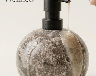 Dispenser di sapone in marmo grigio: design sferico minimalista, pompa nera opaca.