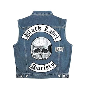 Può includere: Un gilet di jeans blu con una toppa a forma di teschio e le scritte "Black Label Society" e "Society" in bianco. Il gilet ha una chiusura con bottoni e una piccola toppa con le lettere "SDMF".