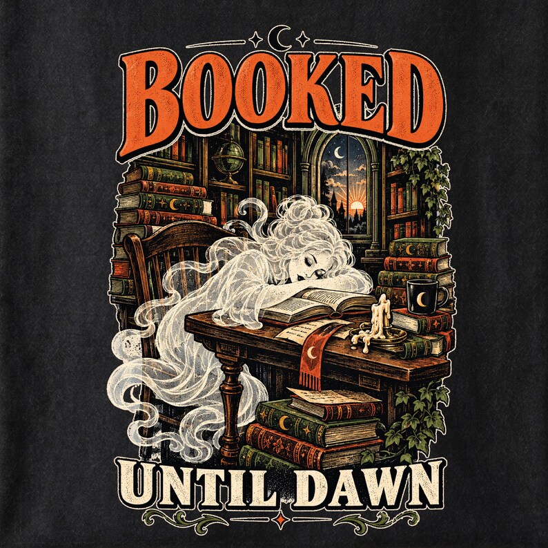 May include: A black t-shirt featuring a graphic illustration of a translucent ghost sleeping at a wooden desk in a library. The text BOOKED UNTIL DAWN is printed in orange. The scene includes stacks of books, a candle, and a window view of a sunset.