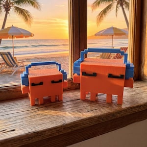 May include: Two orange and blue pixelated figures, resembling a retro boombox or a stylized character, are displayed on a wooden surface. The background shows a beach scene with palm trees, parasols, and a sunset.