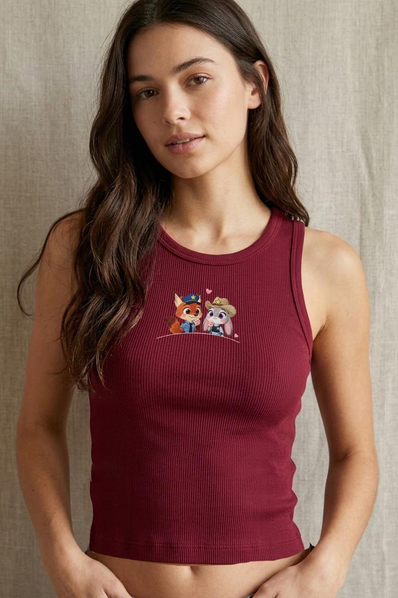 May include: Burgundy ribbed tank top with an embroidered design featuring two cartoon characters. One is a fox wearing a police uniform, and the other is a bunny wearing a cowboy hat. The tank top has a scoop neck and a fitted silhouette.