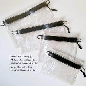 May include: A set of four translucent, crinkled pouches with black zippered closures and pull tabs. The text lists sizes: Small 13cm x 10cm | 5g, Medium 17cm x 12.5cm | 6g, Medium Tall 18cm x 15cm | 8g, Large 23cm x 13cm | 8g, Large Tall 23cm x 15cm | 8g.