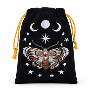 以下が含まれることがあります： 黒いベルベットの巾着袋。刺繍された蛾と星のデザインが施されています。蛾は茶色、白、オレンジ色のアクセントが施された詳細な羽を持っています。白い三日月と星が蛾の上に刺繍されています。巾着は金色です。