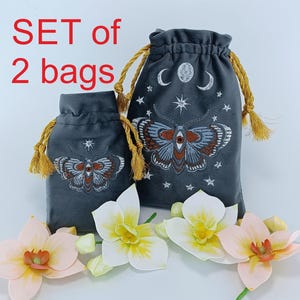 Set med 2 tarotpåsar i sammet med broderi. Handgjorda med guldfärgade dragsnören - lyxiga broderade dödshuvuden med mal, måne och stjärnor.