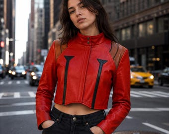 Puede incluir: Una chaqueta corta de cuero rojo con cuello alto y dos botones a presión, mangas largas y detalles de paneles verticales negros en el pecho. La chaqueta incluye detalles en color marrón en los hombros y un dobladillo recto en la cintura.