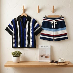Könnte beinhalten: Ein passendes Häkel-Shirt und -Shorts-Set in blau, schwarz und weißen Streifen. Das Shirt hat einen Kragen und kurze Ärmel. Die Shorts haben einen Kordelzug in der Taille. Das Set wird an einer Wand mit einem Holzregal und einer Zeitschrift präsentiert.
