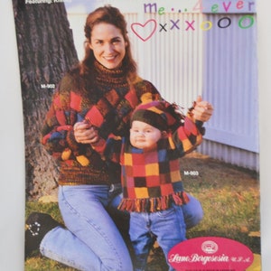 K&ouml;nnte beinhalten: Eine Frau und ein Kind tragen passende bunte Pullover mit einem Rautenmuster. Die Frau tr&auml;gt eine blaue Jeans und das Kind tr&auml;gt eine blaue Jeans und eine M&uuml;tze. Der Text "Mommy and Me... 4 ever" ist auf einem wei&szlig;en Zaun hinter ihnen geschrieben.
