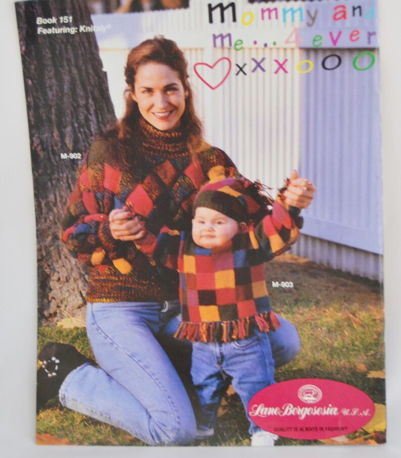 K&ouml;nnte beinhalten: Eine Frau und ein Kind tragen passende bunte Pullover mit einem Rautenmuster. Die Frau tr&auml;gt eine blaue Jeans und das Kind tr&auml;gt eine blaue Jeans und eine M&uuml;tze. Der Text "Mommy and Me... 4 ever" ist auf einem wei&szlig;en Zaun hinter ihnen geschrieben.