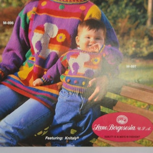 K&ouml;nnte beinhalten: Eine Frau und ein Kind tragen passende bunte Strickpullover mit einem fantasievollen Tiermotiv. Die Pullover sind in verschiedenen Farben gehalten, darunter Lila, Rosa, Gelb, Gr&uuml;n und Blau. Die Pullover sind aus einem strukturierten Strickstoff gefertigt und haben ein verspieltes, fantasievolles Design. Die Pullover sind Teil einer Strickmusterkollektion von Lane Borgosesia U.P.A. mit Knitaly.